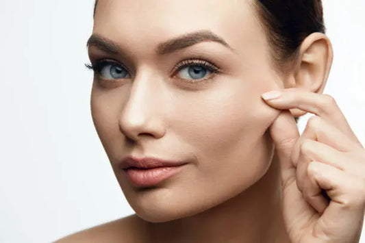 Close-up of clear skin and cheek pinch demonstrating facial elasticity and healthy collagen levels