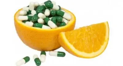 Orange half filled with capsules, blending natural vitamin C with supplements