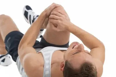 Athlete clutching knee in pain, suggesting possible meniscus injury during physical activity.