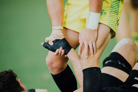 Sports player helping team member up